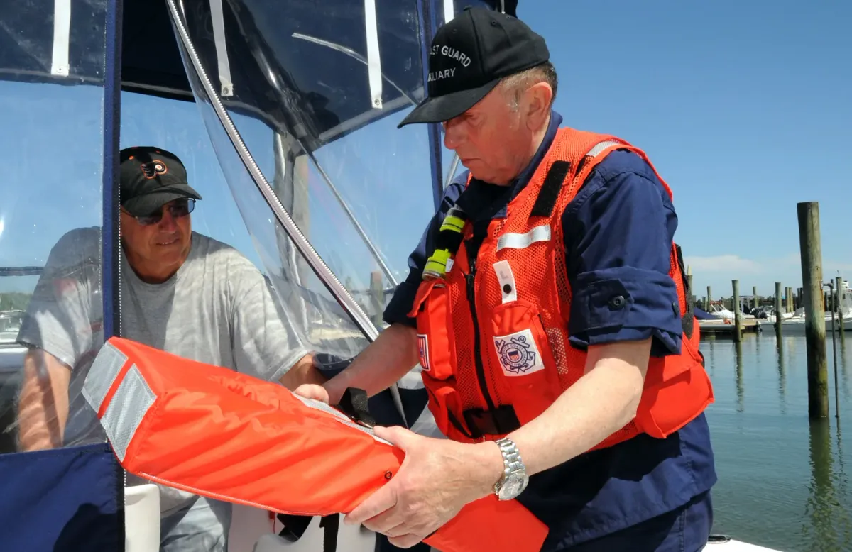 A Coast Guard Auxiliary volunteer inspecting a life jacket