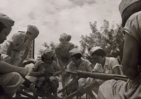 Newly assigned WACs watch Chinese WACs dismantle their rifles, 1945. American WACs were not trained on weapons as were their Chinese counterparts. (Photo courtesy of U.S. Army Women's Museum)