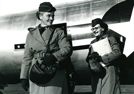Carolyn James and Louise Farrell, the first two members of the Women's Army Corps to be assigned to the 8th US Army in Korea, debark from a plane at the K-16 airstrip. (Photo courtesy of U.S. Army Women's Museum)